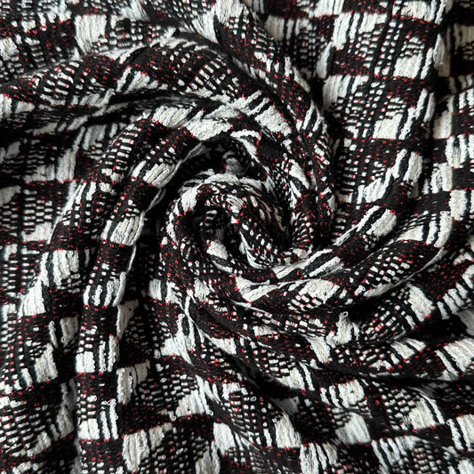 Tissu en tweed graphique coton noir, blanc et rouge de la marque Tiss'ART, visible avec motifs colorés et texture tissée.