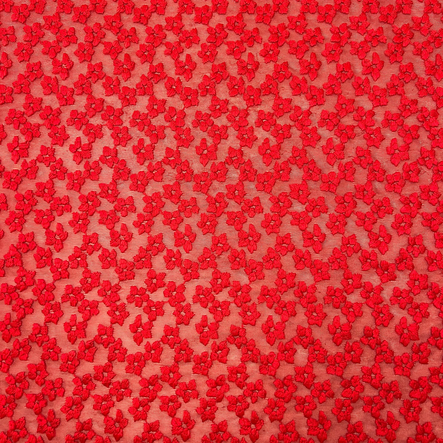Red floral embroidered tulle fabric by Tiss'ART, showcasing intricate flower designs on a delicate sheer background.