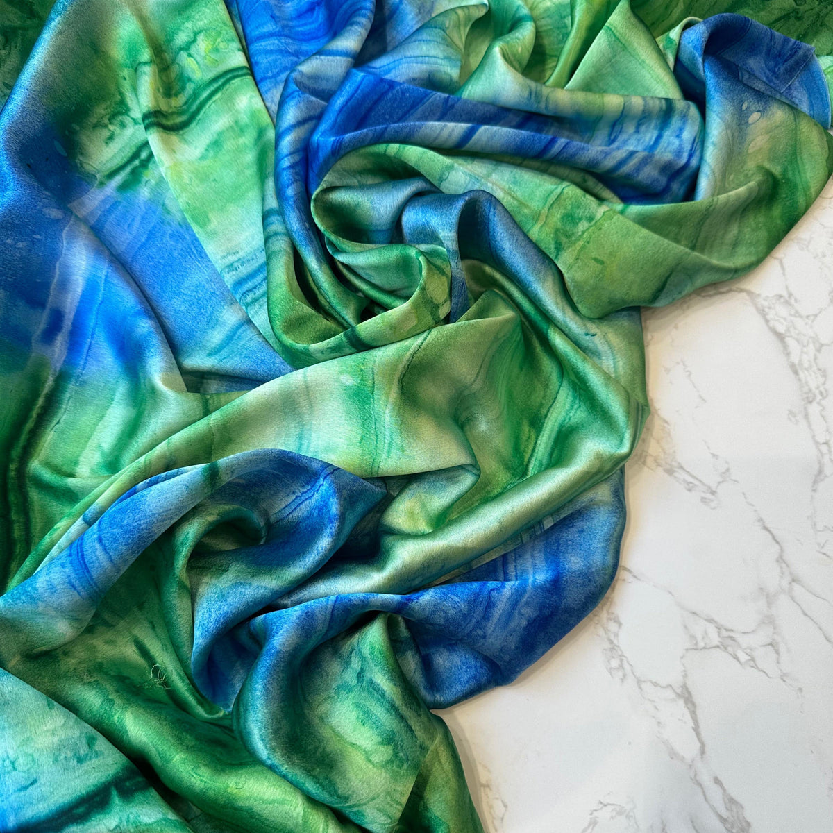 Satin imprimé "Étreinte Minérale" vert et bleu de Tiss'ART, texture satin élégante avec motif abstrait.